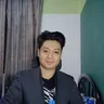 Christian T. Macion, dark blazer over graphic tee, three-quarter view, neutral background. Photographed February 2026.