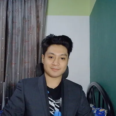 Christian T. Macion, dark blazer over graphic tee, three-quarter view, neutral background.
